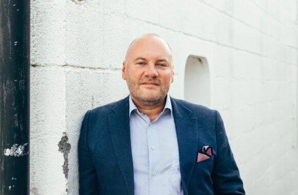 A photo of Neil Thody dressed in a smart suit against a white background.